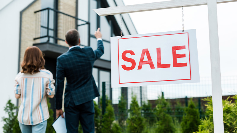 A real estate agent showing a house for sale to a woman client