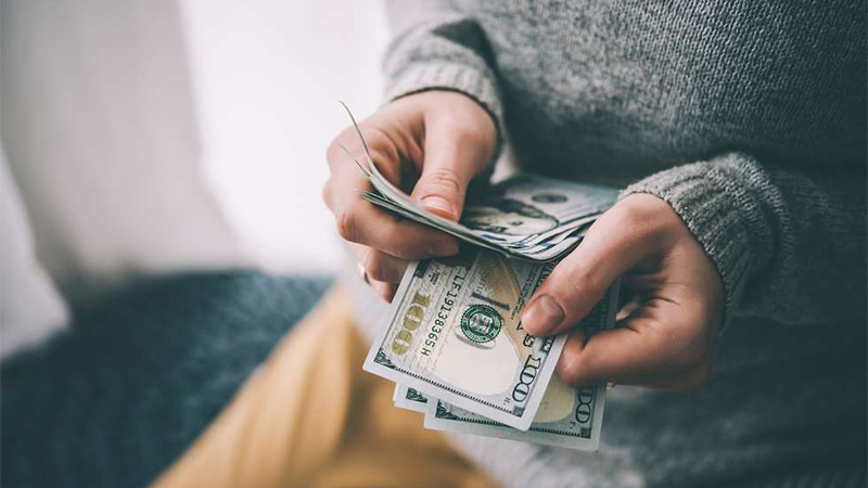 Image of person holding and counting cash