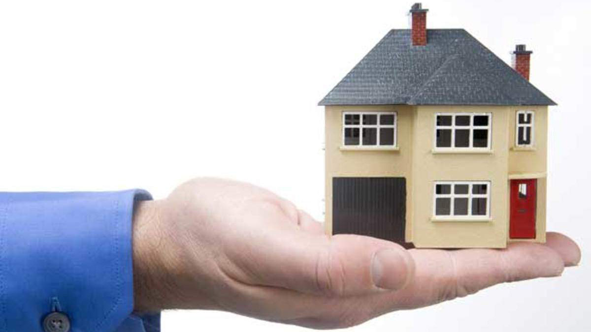 Image of miniature house on top of a person's hand