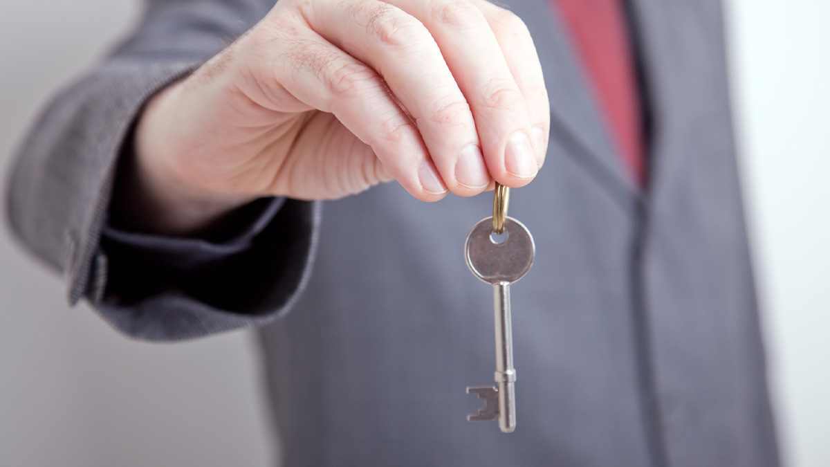 A man holding a key for a house he sold.