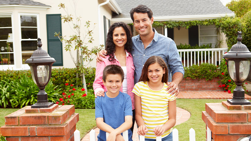 A family in front of their new house from rent to own with Landis.